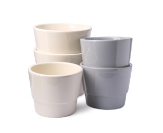 Different empty ceramic flower pots on white background