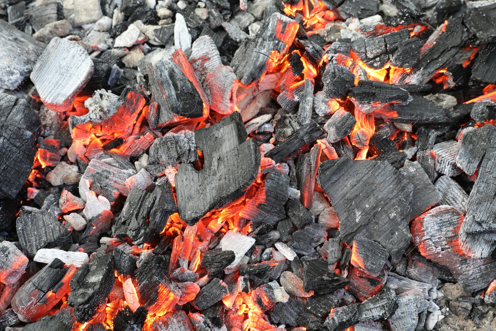 Photo of Many smoldering coals as background, closeup view