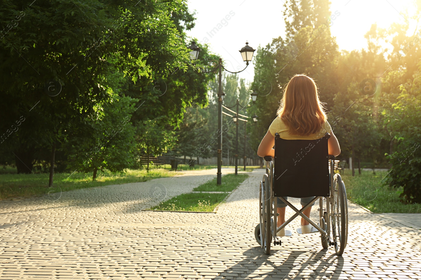 Photo of Woman in wheelchair at park on sunny day. Space for text