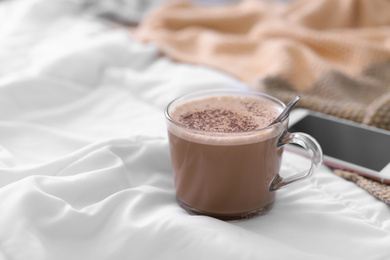Photo of Cup of morning coffee on bed indoors