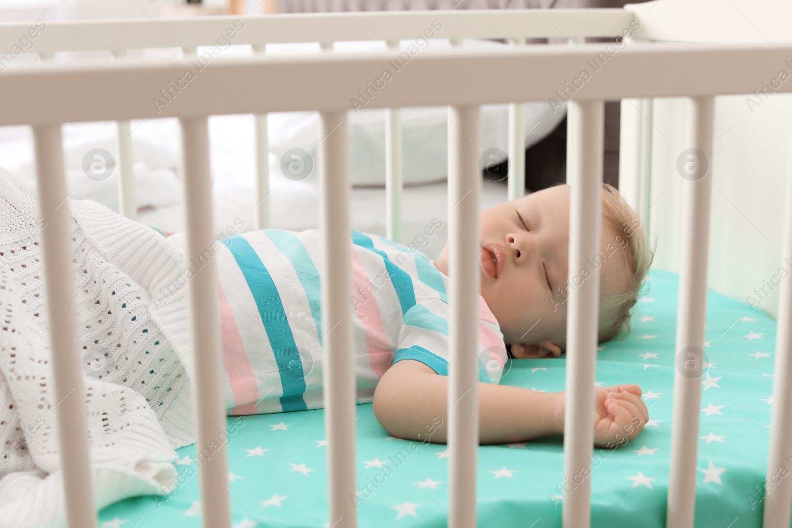 Photo of Cute little child sleeping in crib at home