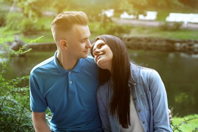 Affectionate young couple sitting together in park