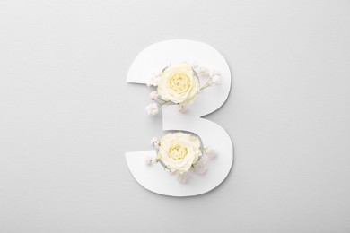 Photo of Paper number 3 and beautiful flowers on light grey background, top view