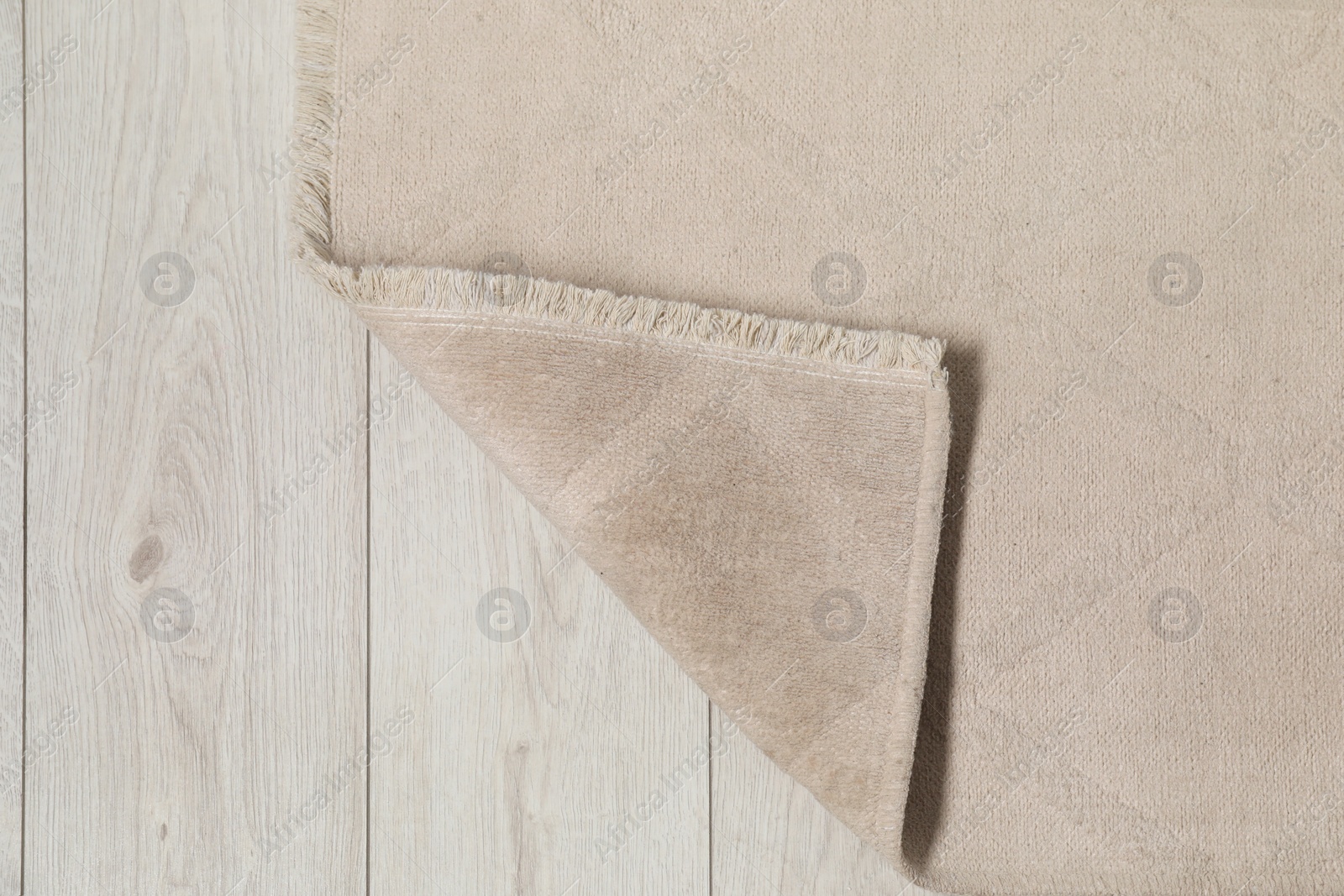 Photo of Soft beige carpet on white laminated floor indoors, top view. Space for text