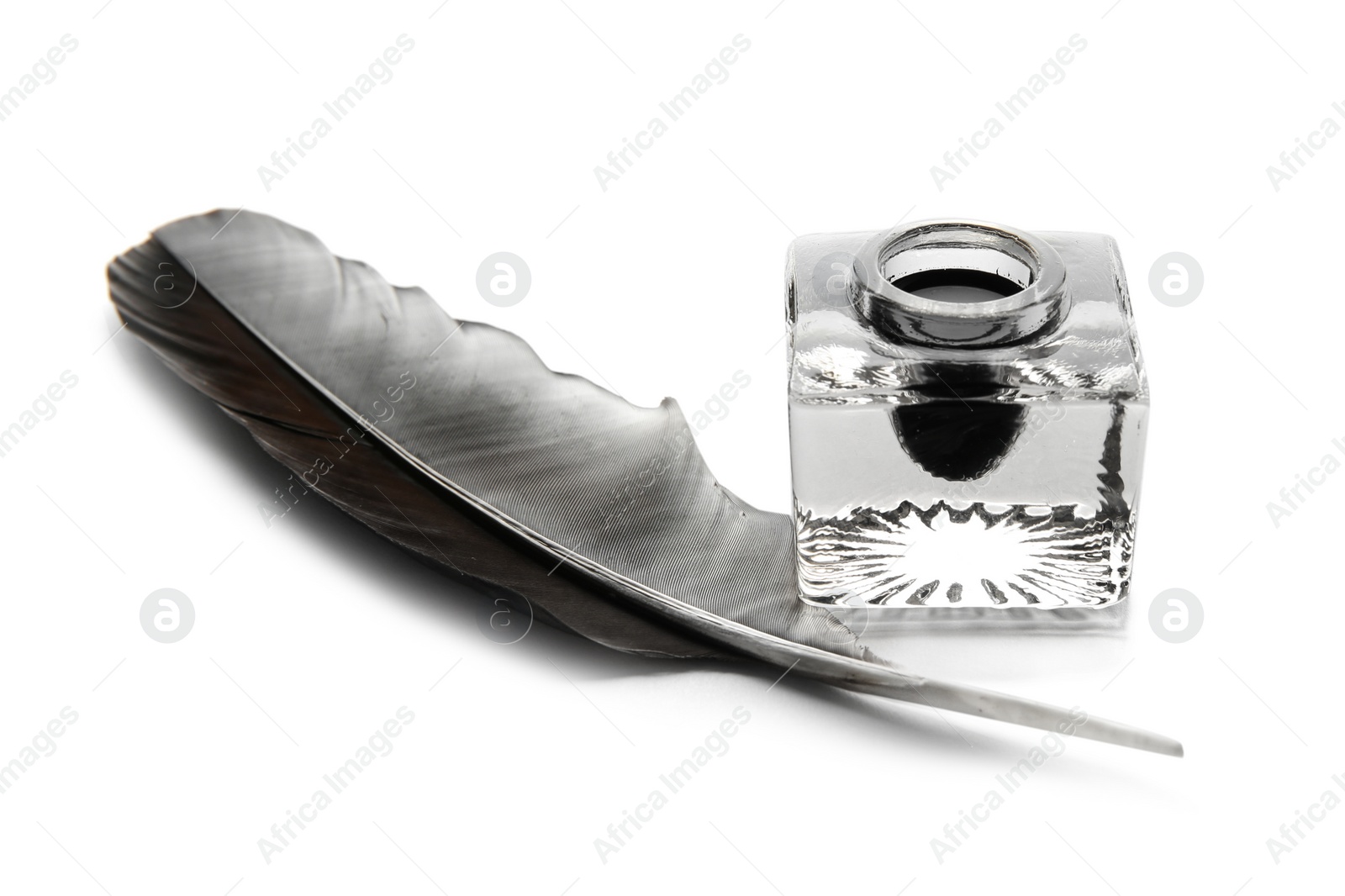 Photo of Feather pen and inkwell on white background