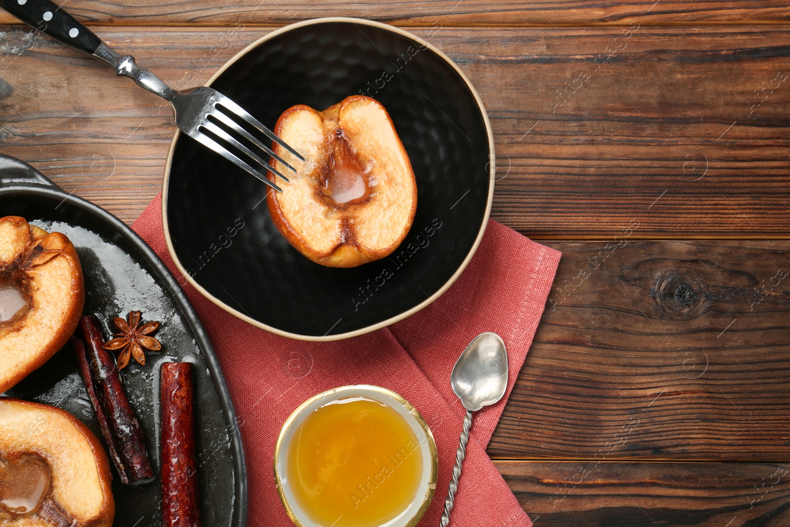 Photo of Tasty baked quinces served with honey on wooden table, flat lay. Space for text