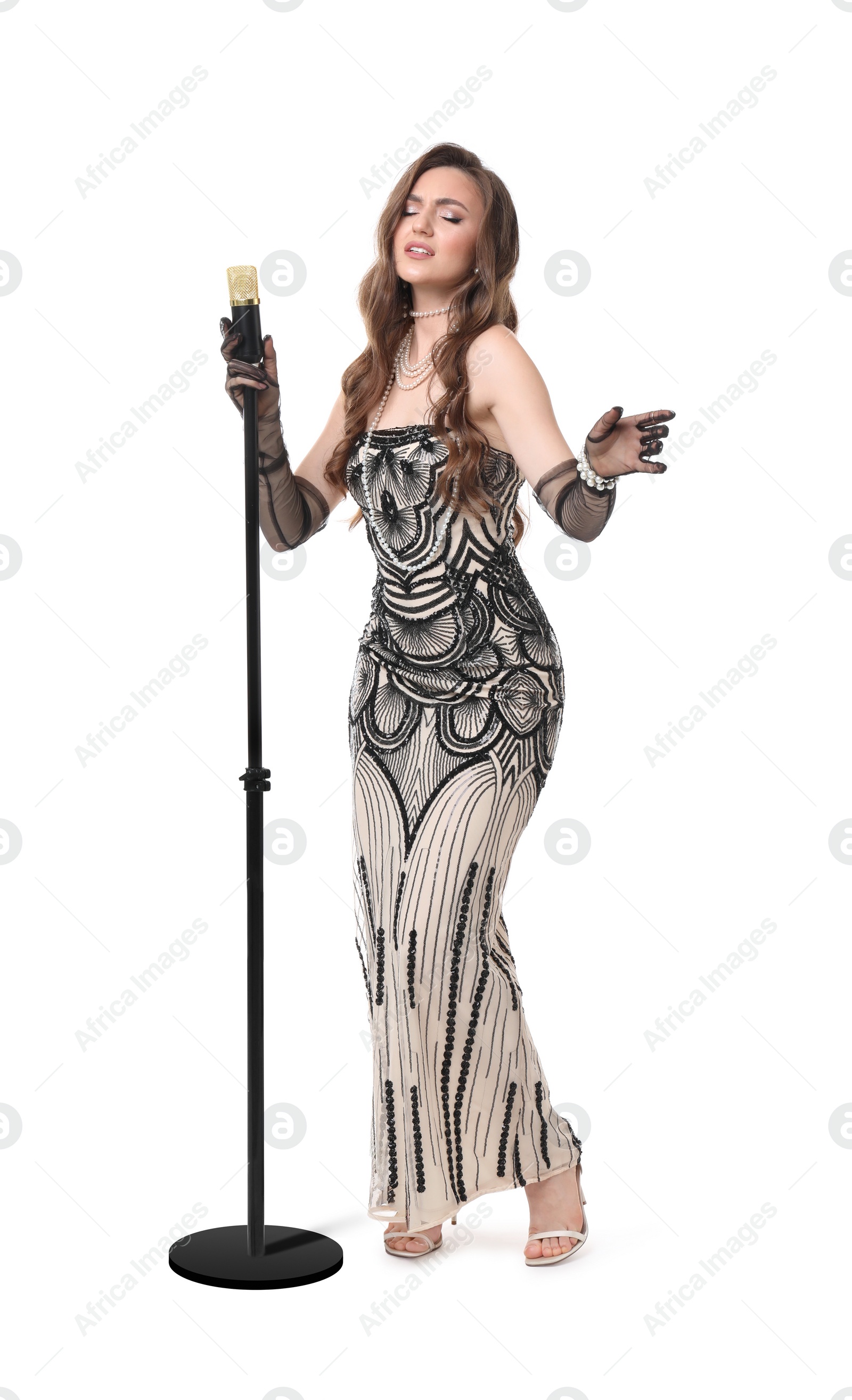 Photo of Beautiful young woman in stylish dress with microphone singing on white background