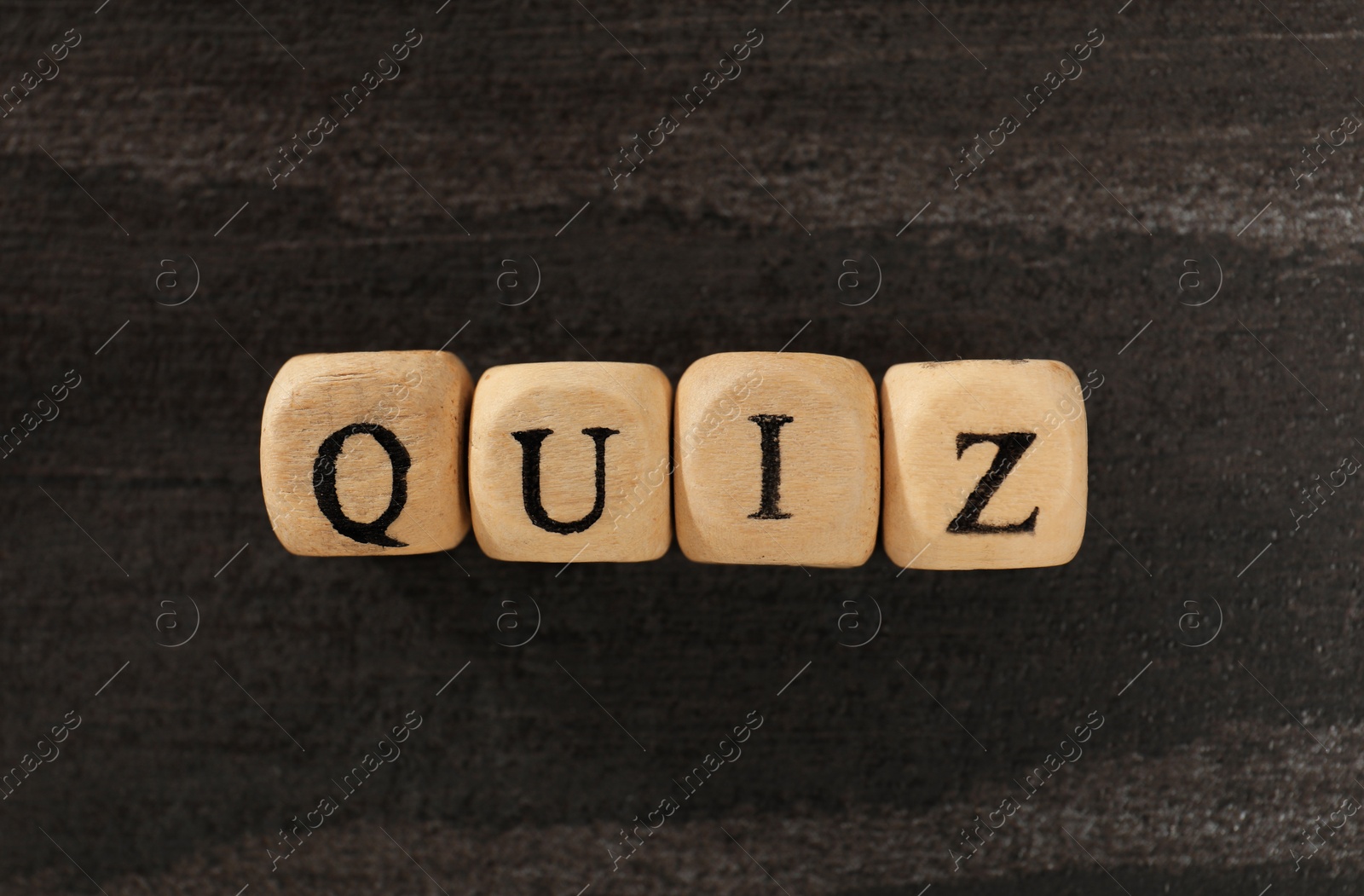 Photo of Cubes with word Quiz on wooden table, flat lay