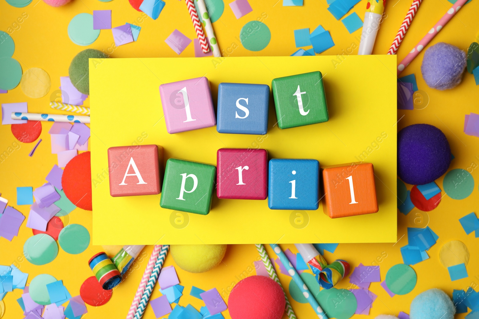 Photo of Colorful cubes with words 1st APRIL on yellow background, flat lay