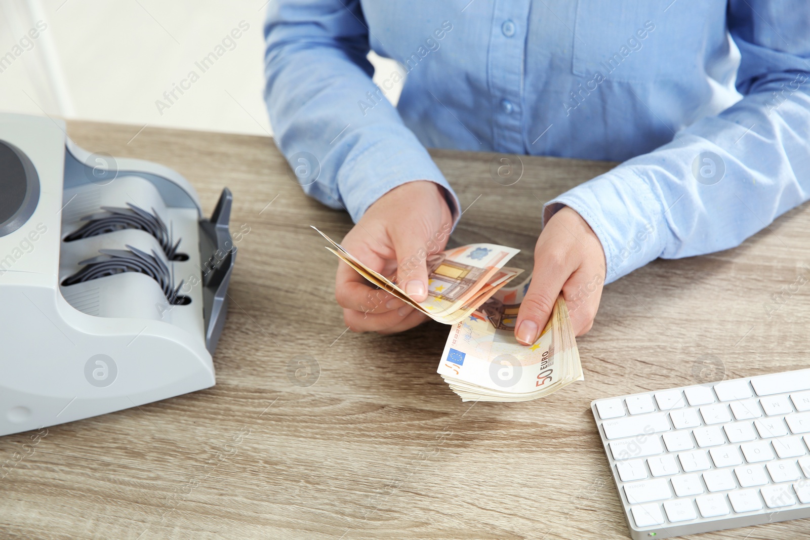 Photo of Female teller counting money at cash department, closeup