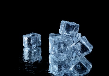 Transparent ice cubes on black mirror surface