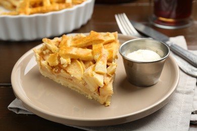 Piece of tasty homemade quince pie with ice cream on table, closeup