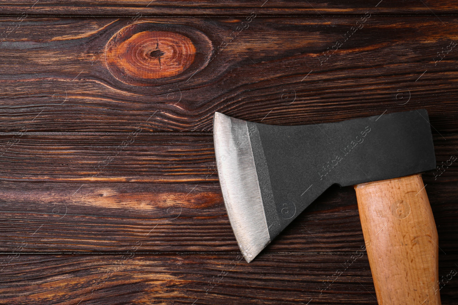 Photo of Ax with handle on wooden table, top view. Space for text