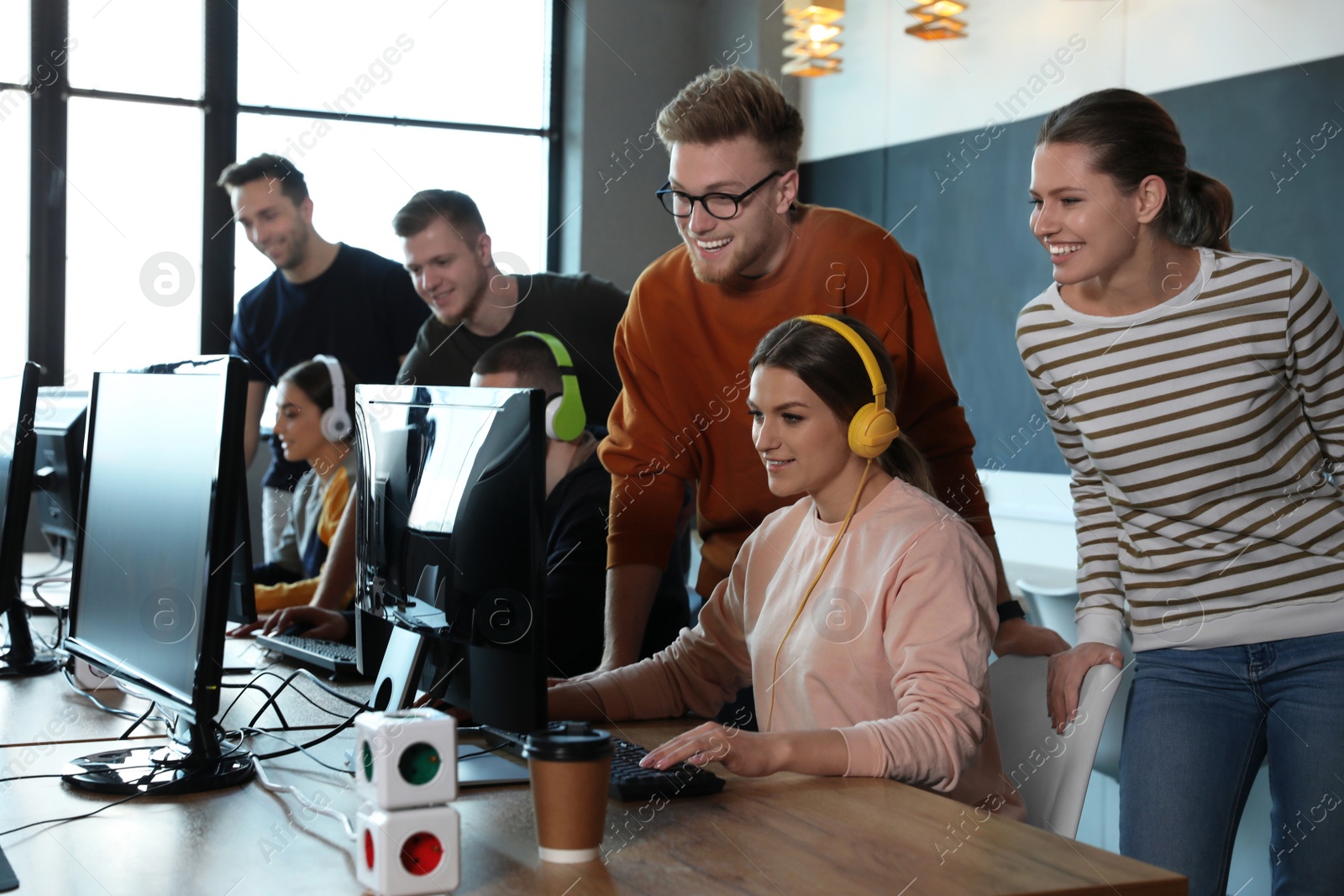 Photo of Group of people playing video games in internet cafe