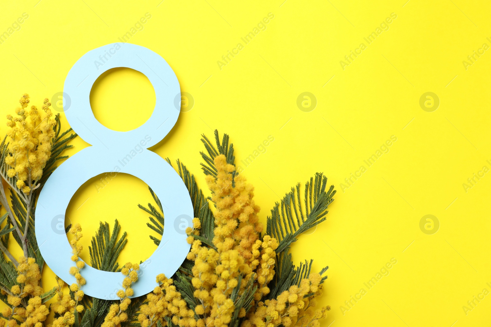 Photo of 8 March greeting card design with beautiful mimosa flowers on yellow background, flat lay. Space for text