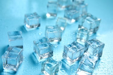 Photo of Ice cubes and water drops on turquoise background. Ingredient for refreshing drink