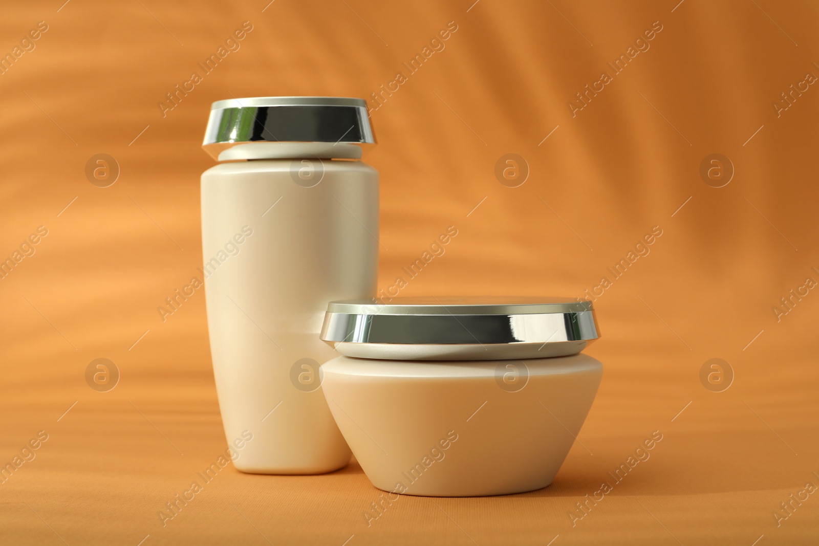 Photo of Hair care cosmetic products on orange background