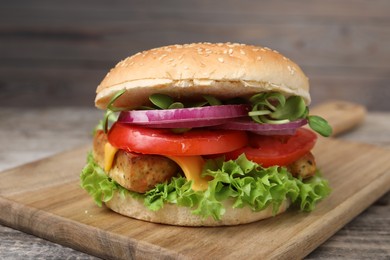 Photo of Delicious burger with tofu and fresh vegetables on table, closeup
