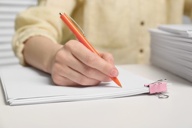 Photo of Woman signing documents at table in office, closeup