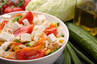 Photo of Tasty salad with Chinese cabbage, carrot, cheese, cucumber and tomato on table, closeup