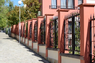 Metal beautiful fence on city street near building