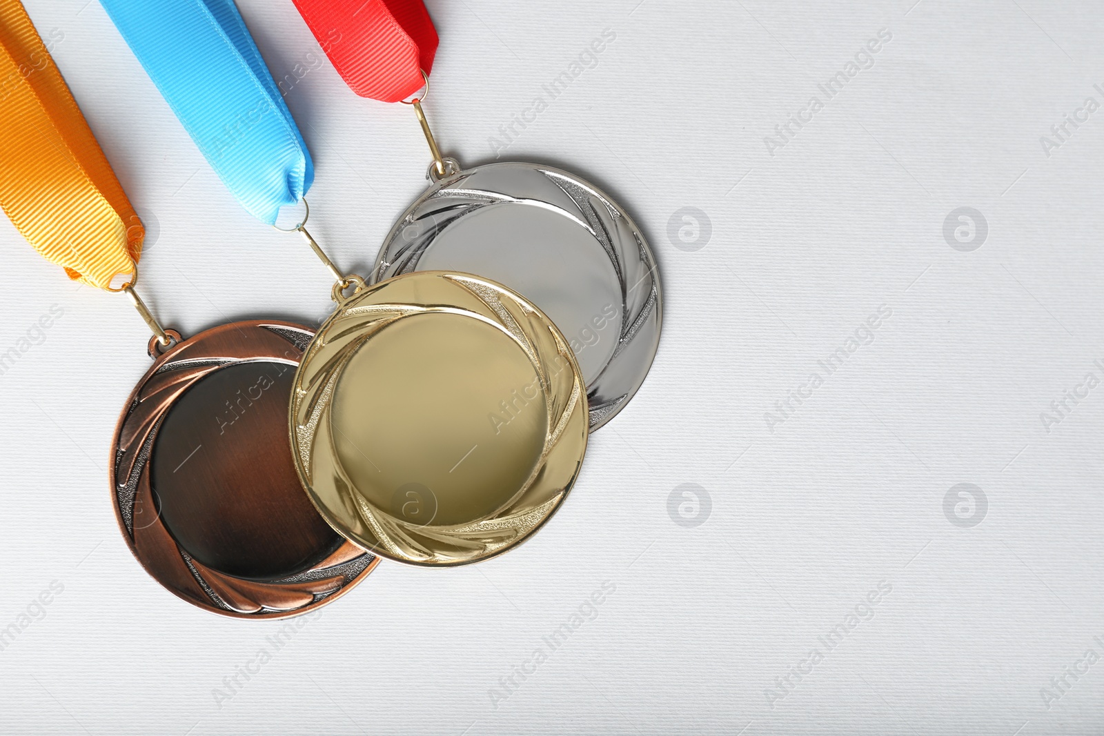 Photo of Gold, silver and bronze medals on white background, flat lay. Space for design