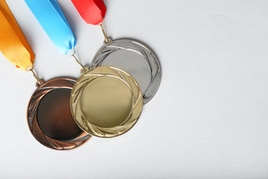 Gold, silver and bronze medals on white background, flat lay. Space for design