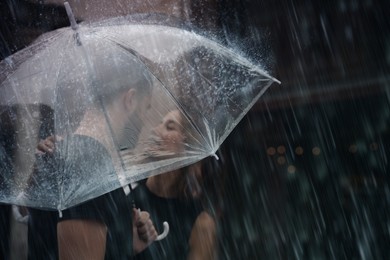 Image of Young couple with umbrella enjoying time together under rain on city street, space for text