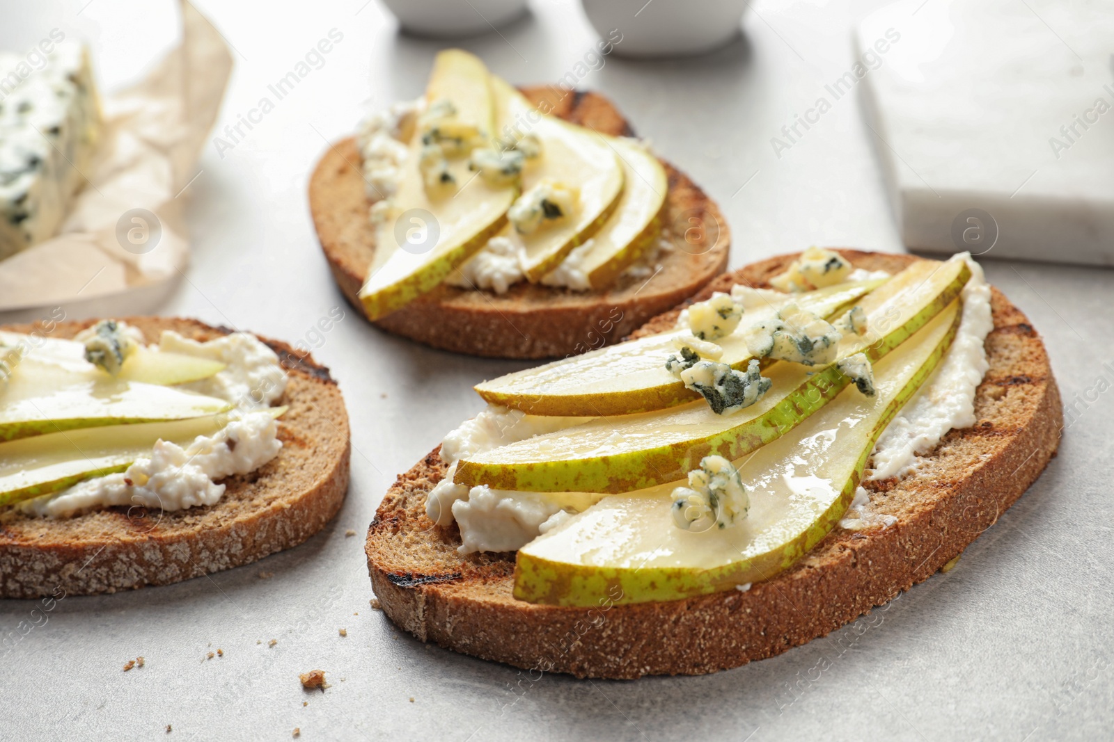 Photo of Delicious bruschettas with pear served on table, closeup