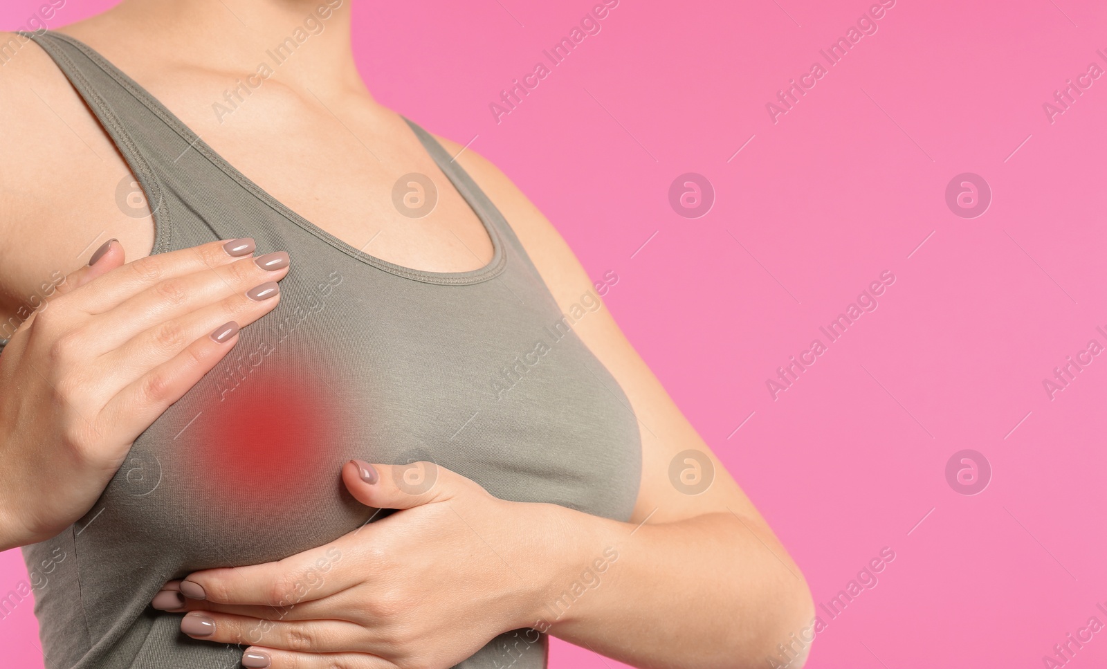 Image of Woman checking her breast on pink background, closeup