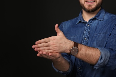 Photo of Man showing STOP gesture in sign language on black background, space for text