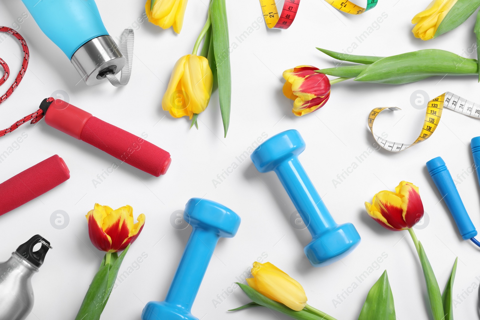 Photo of Composition with spring flowers and sports items on white background, top view