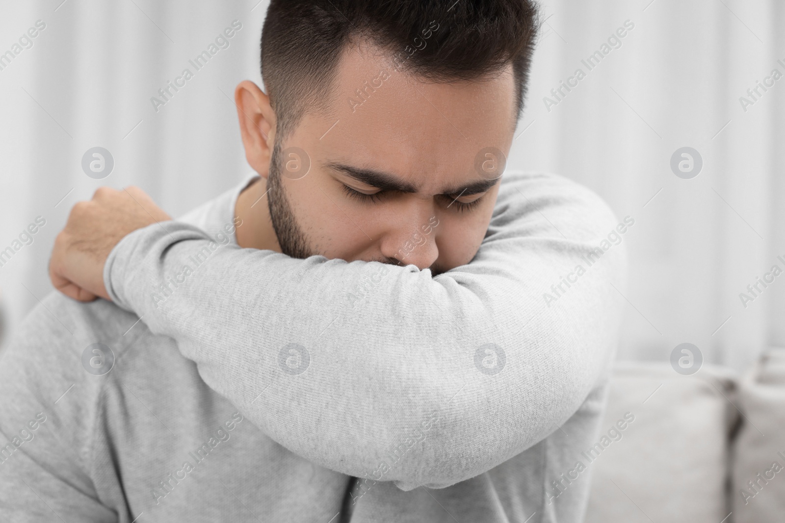 Photo of Sick man coughing at home, closeup. Cold symptoms