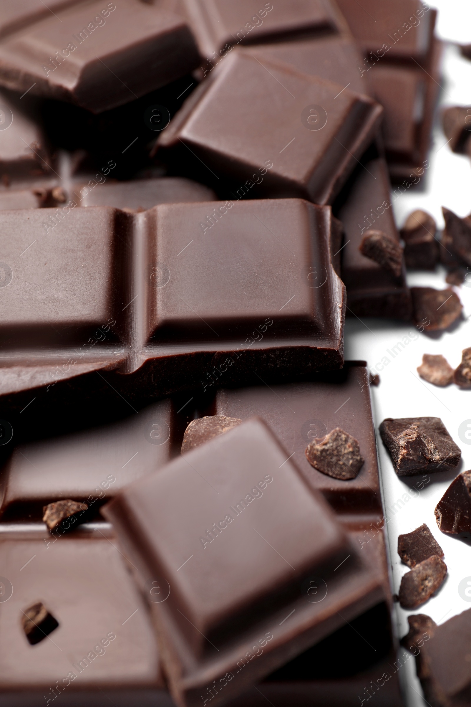 Photo of Pieces of delicious dark chocolate bar on white background, closeup