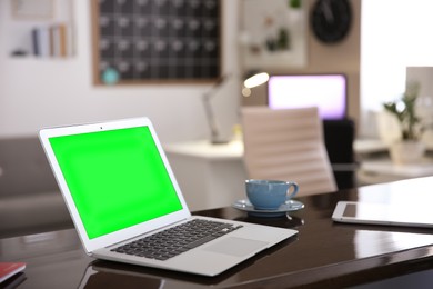 Laptop display with chroma key on desk in room. Comfortable workplace with modern computer