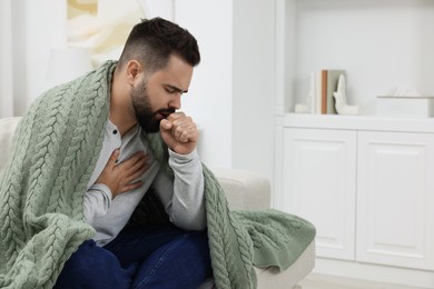 Photo of Sick man coughing at home, space for text
