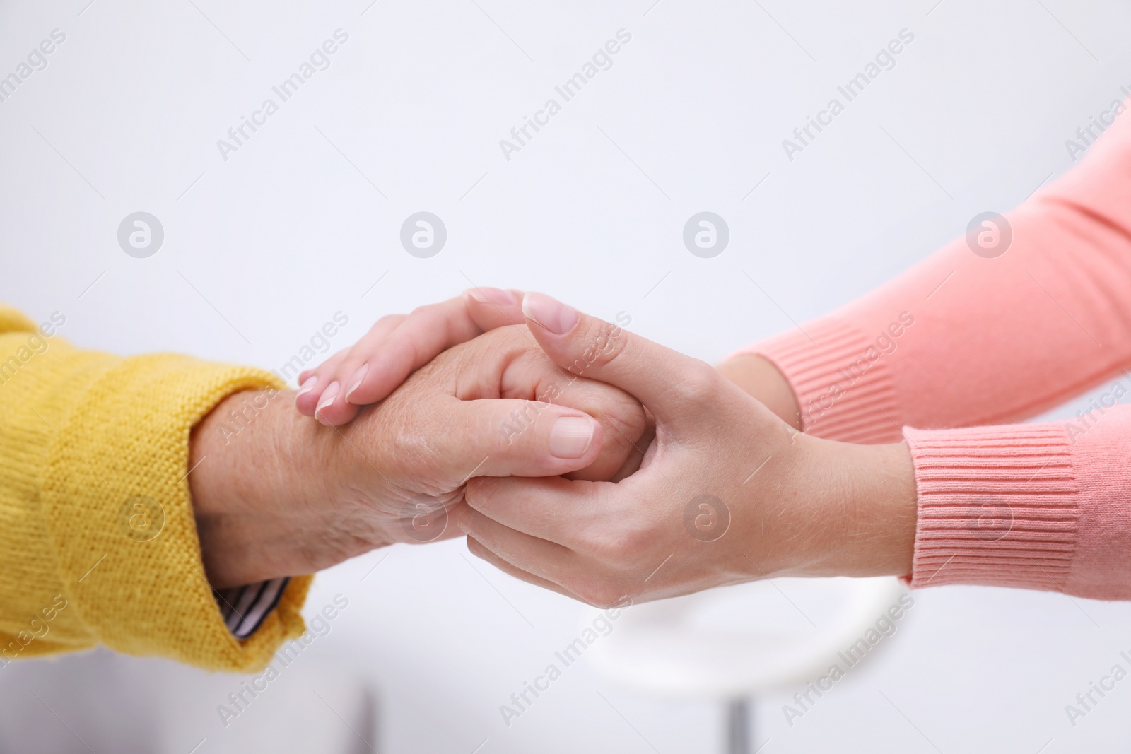 Photo of People holding hands together indoors. Help and elderly care service