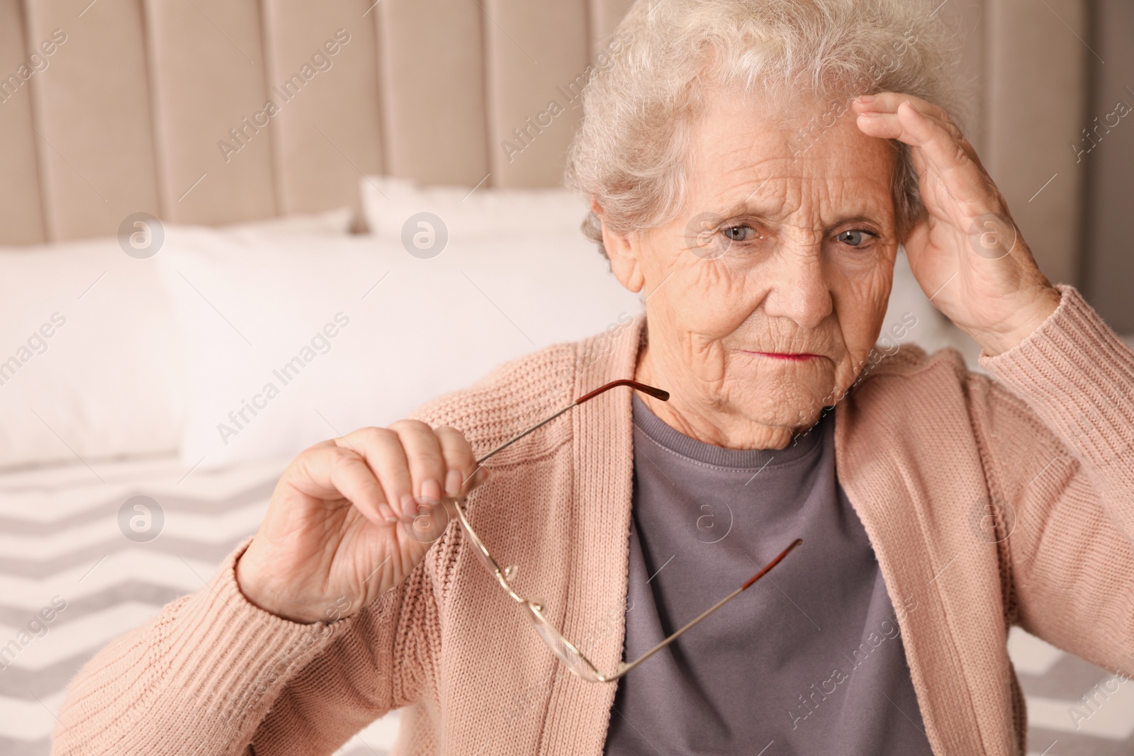 Photo of Senior woman with headache in bedroom at home