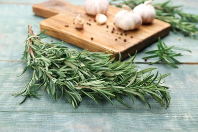 Photo of Bunch of fresh rosemary on light blue wooden table