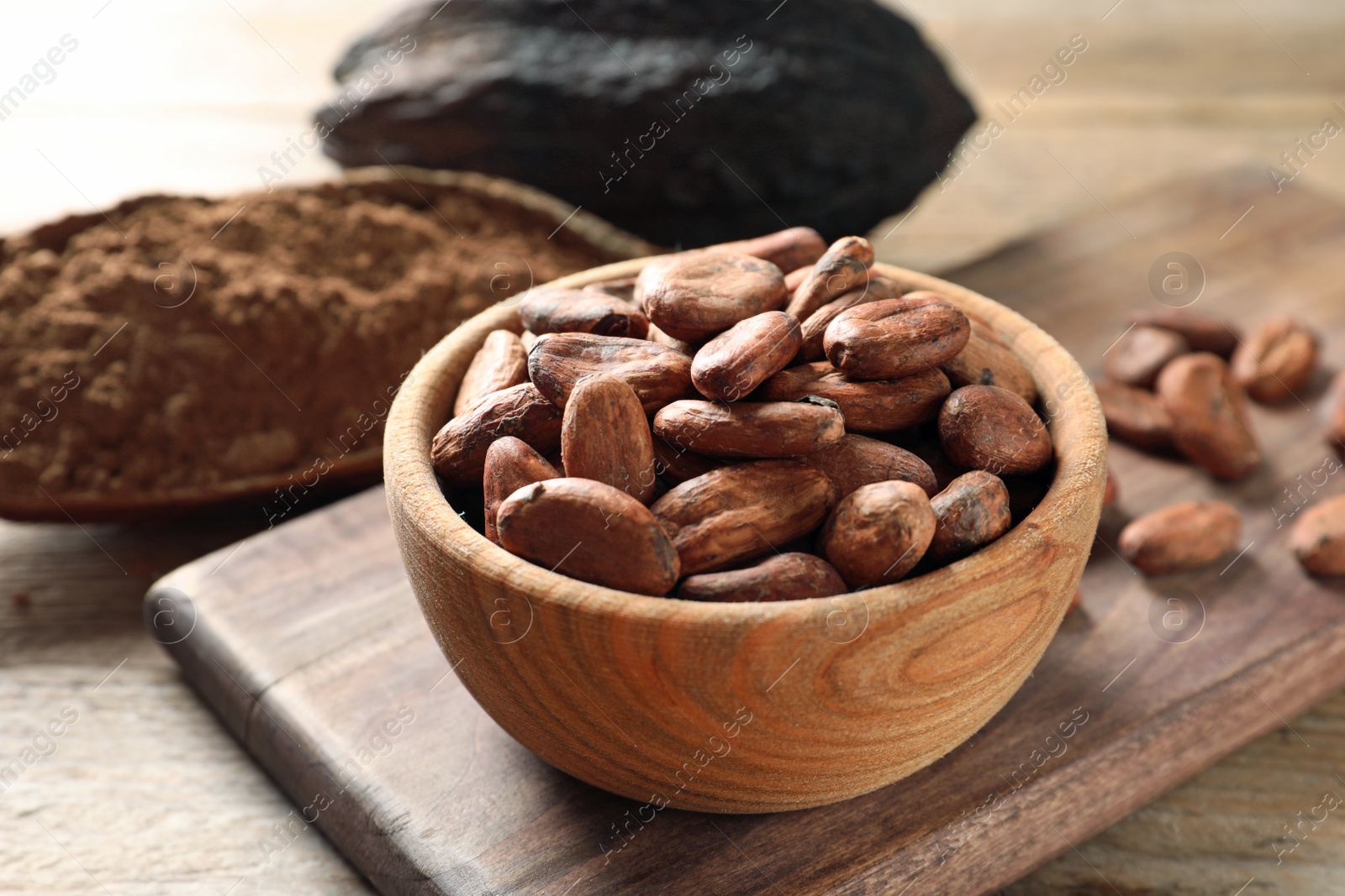 Photo of Wooden bowl with cocoa beans on table