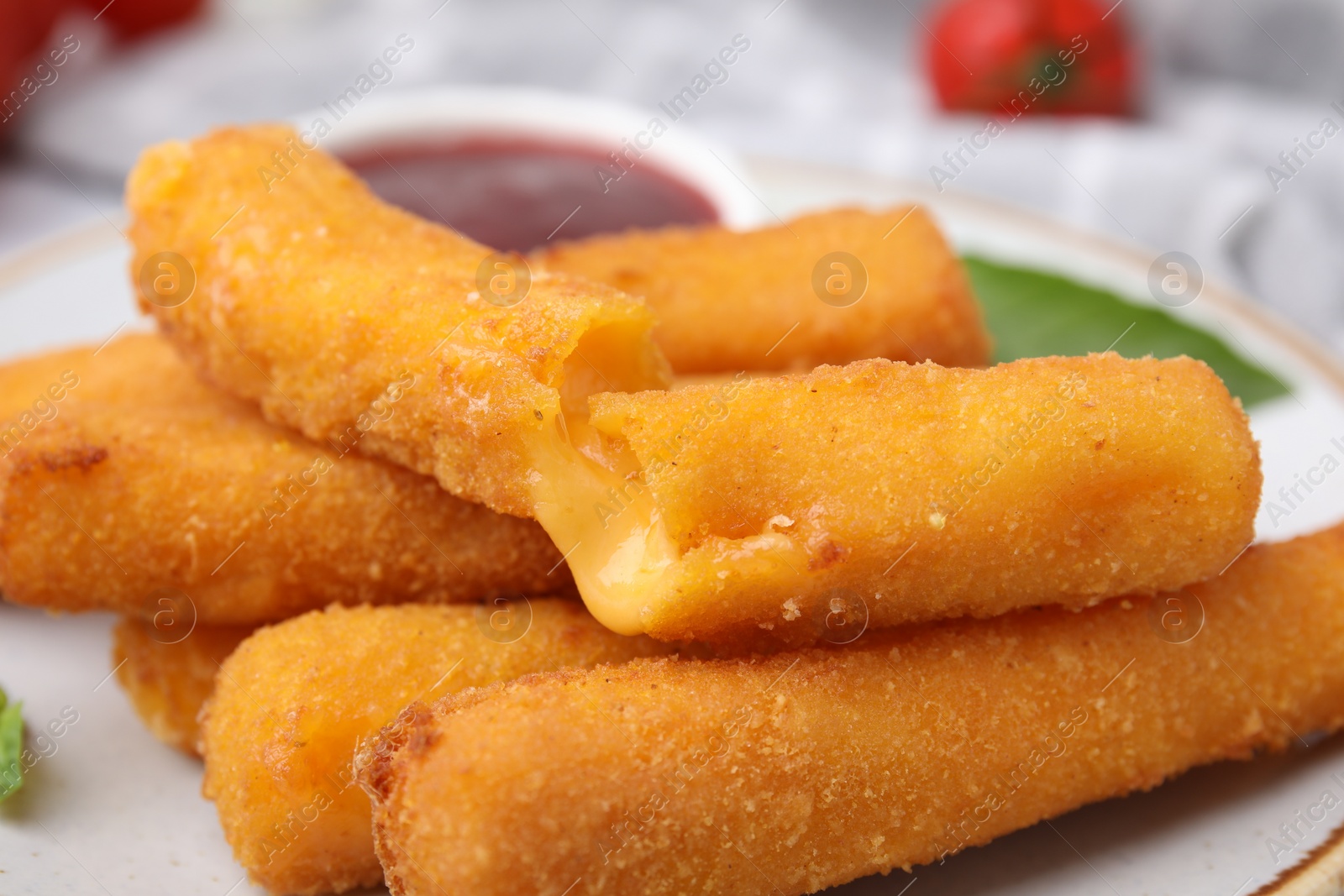 Photo of Tasty fried mozzarella sticks on white plate, closeup