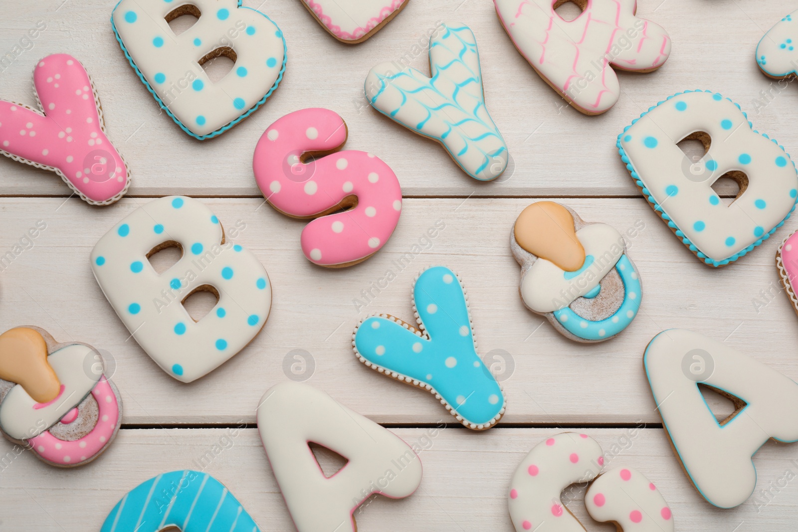 Photo of Set of baby shower cookies on white wooden table, flat lay