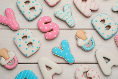 Photo of Set of baby shower cookies on white wooden table, flat lay