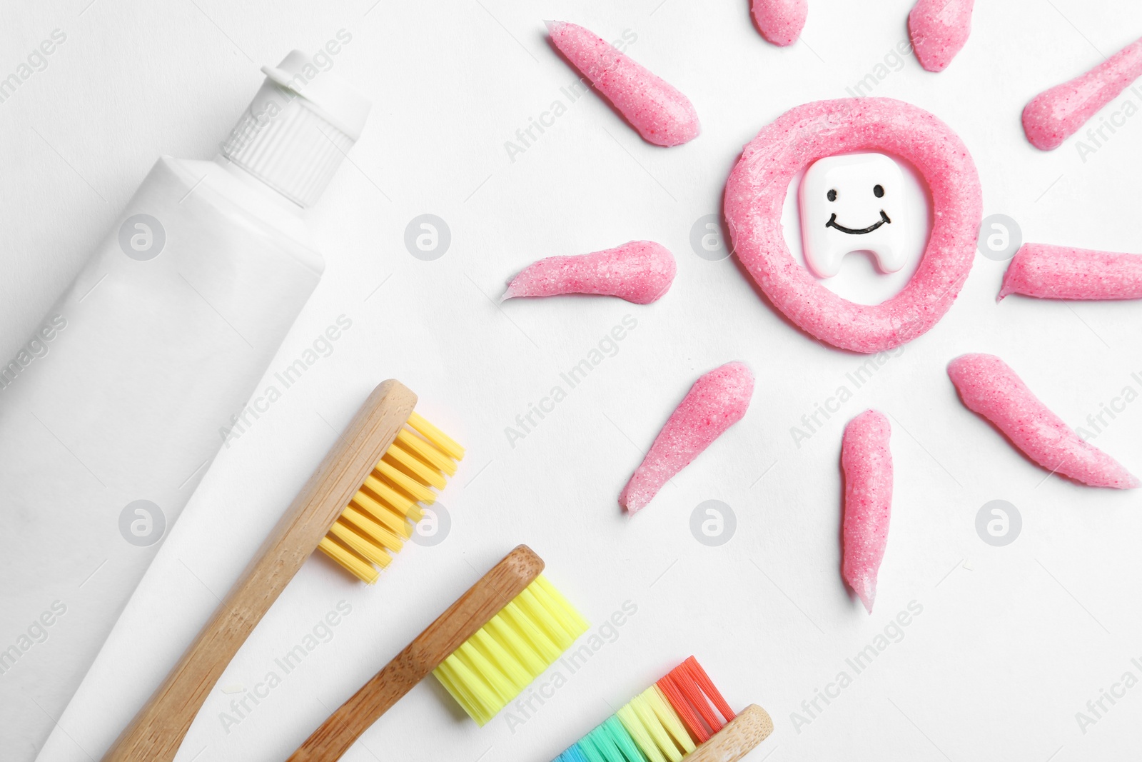 Photo of Composition small plastic tooth and oral care products on white background