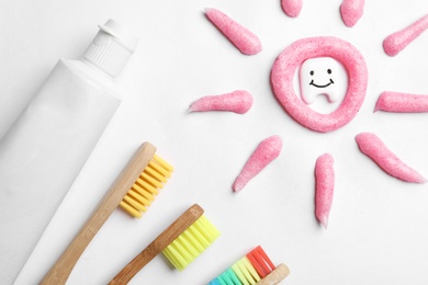 Composition small plastic tooth and oral care products on white background