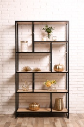 Photo of Shelving with different decor near white brick wall. Interior design
