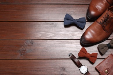 Photo of Stylish bow ties, shoes, wallet and wristwatch on wooden background, flat lay. Space for text