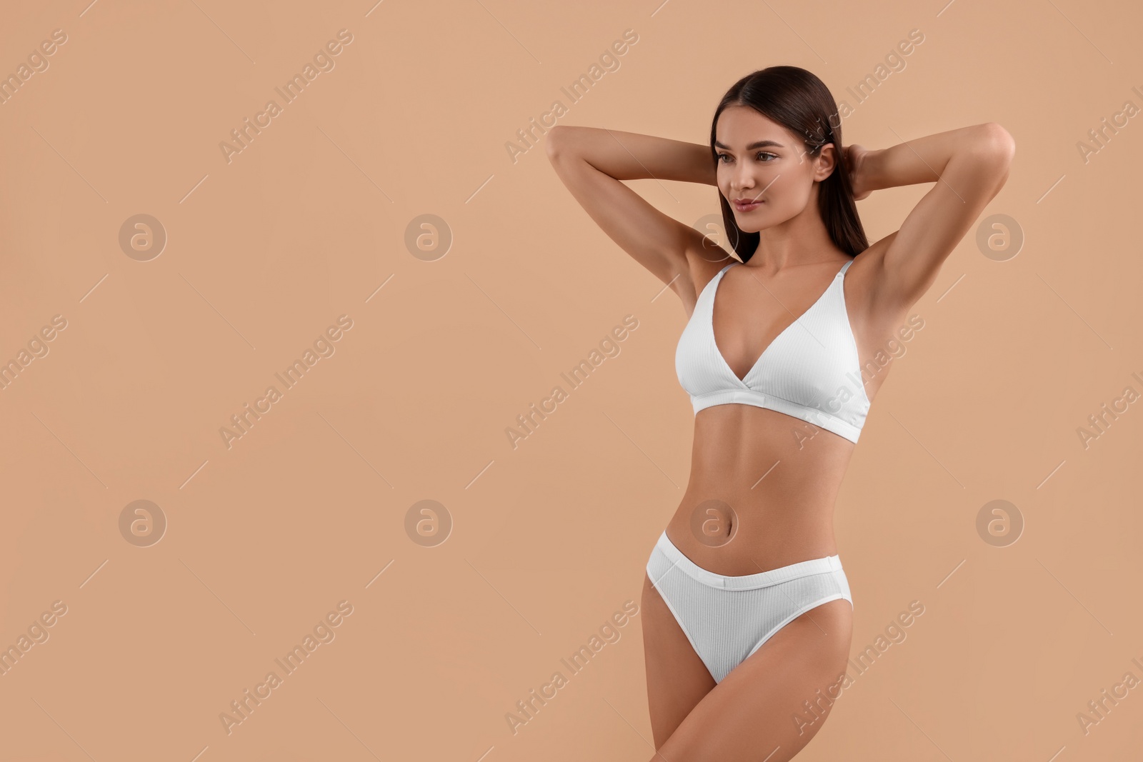 Photo of Young woman in stylish white bikini on beige background. Space for text