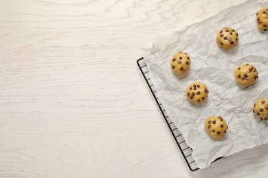 Photo of Uncooked chocolate chip cookies on white wooden table, top view. Space for text