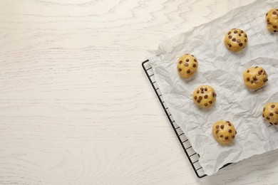 Uncooked chocolate chip cookies on white wooden table, top view. Space for text